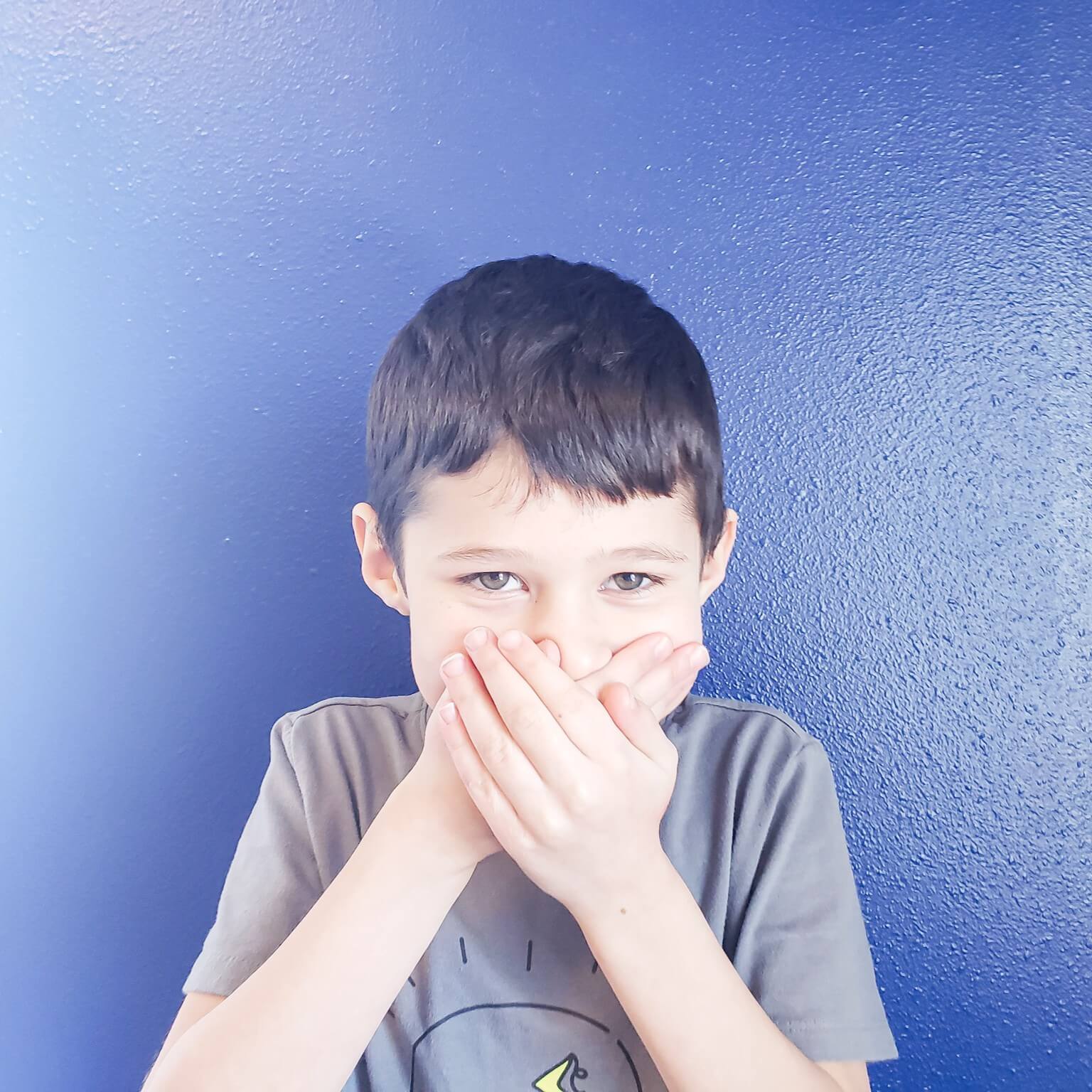 Child covering mouth, avoiding food or mealtime interaction