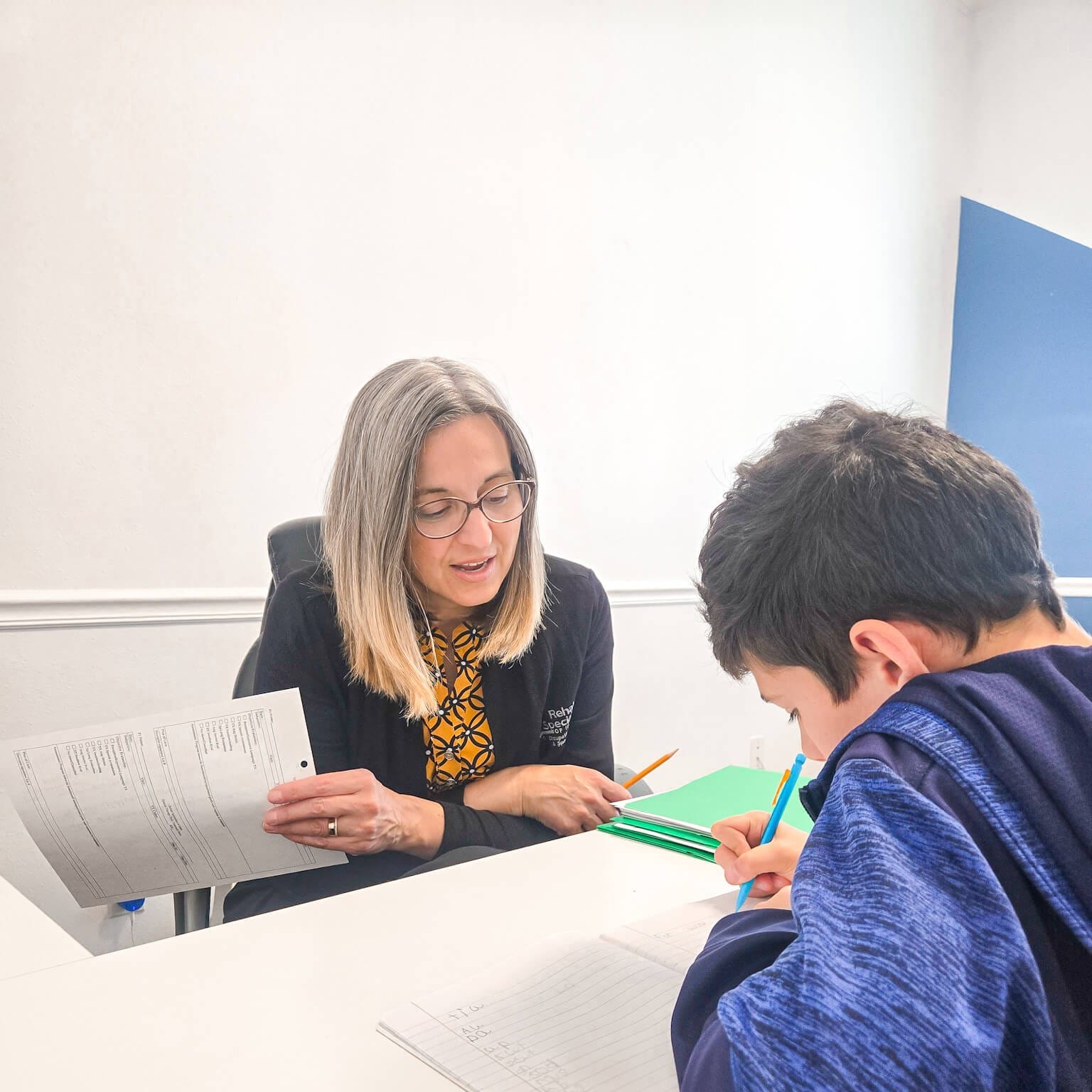 Speech therapist coaching child to improve language development